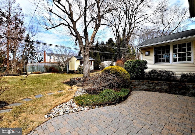 view of yard with fence and an outdoor structure