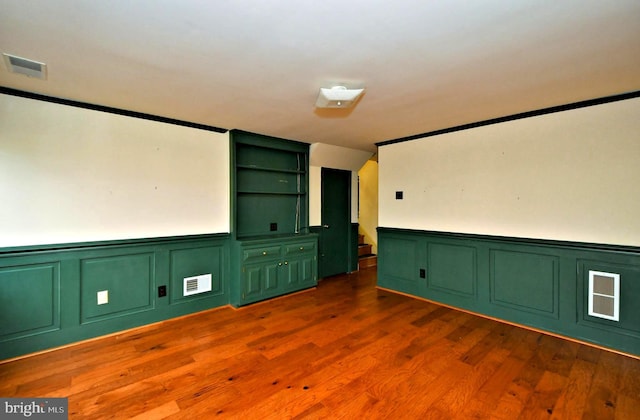 interior space with dark wood-style floors, wainscoting, stairs, and visible vents