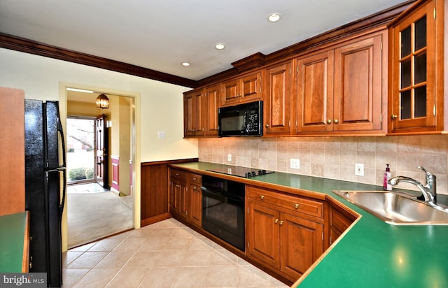 kitchen with black appliances, brown cabinets, a sink, and light tile patterned flooring