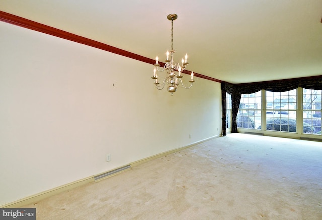 carpeted empty room featuring visible vents, a notable chandelier, and baseboards