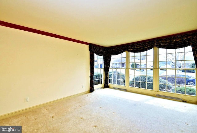 carpeted spare room with visible vents, plenty of natural light, and baseboards