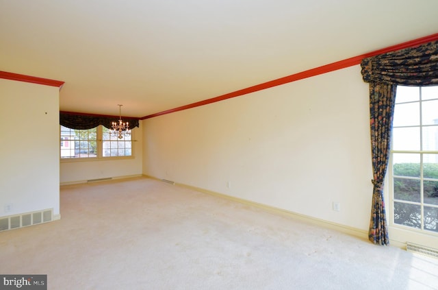 carpeted empty room featuring visible vents, a chandelier, and ornamental molding