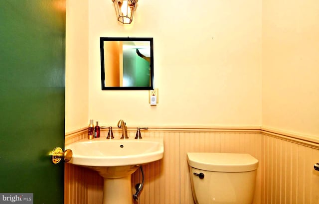 bathroom with wainscoting and toilet