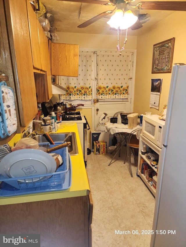 kitchen with light tile patterned floors, white appliances, and a ceiling fan