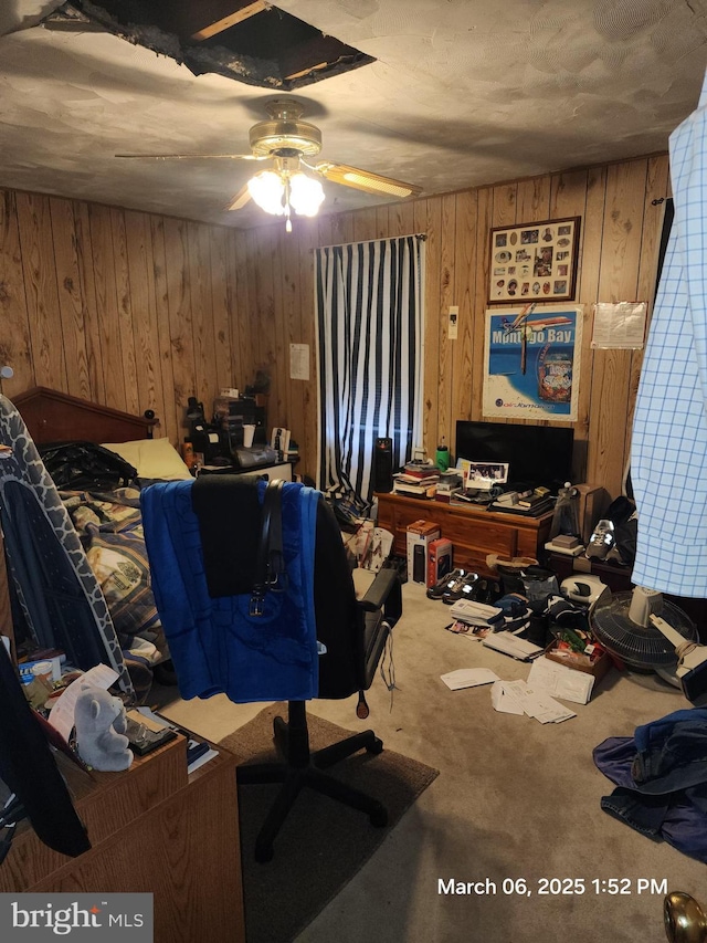 office space with carpet flooring, ceiling fan, and wood walls