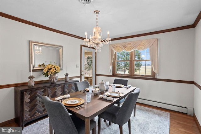 dining area with crown molding, a baseboard radiator, an inviting chandelier, wood finished floors, and baseboards