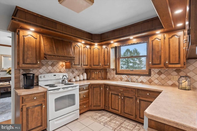 kitchen featuring light countertops, a sink, white electric range oven, and custom range hood