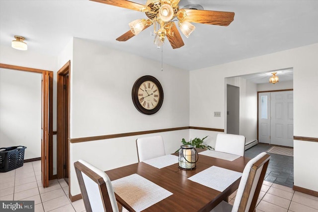 dining space featuring a ceiling fan, a baseboard radiator, baseboards, and light tile patterned floors