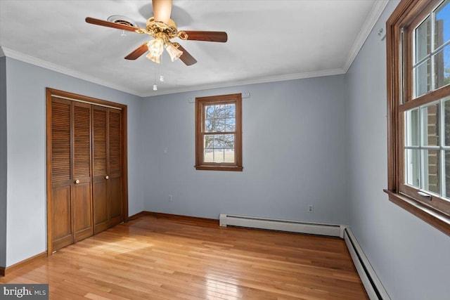 unfurnished bedroom with light wood-style floors, a baseboard radiator, a baseboard heating unit, and crown molding