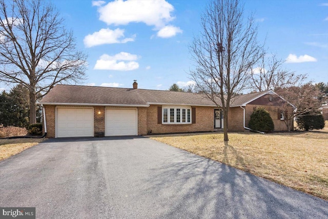 ranch-style house with aphalt driveway, a front lawn, brick siding, and a garage