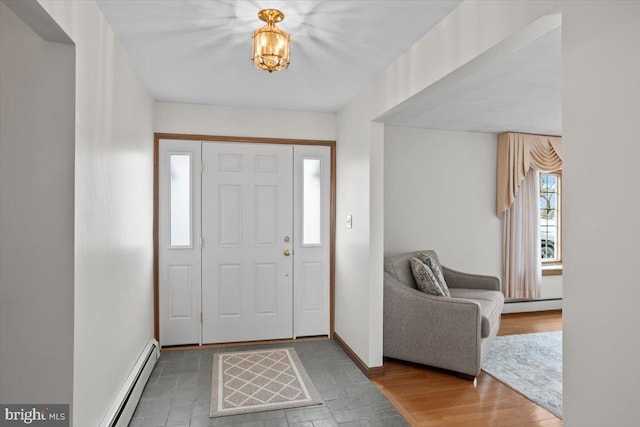 foyer featuring a baseboard radiator, baseboards, and wood finished floors