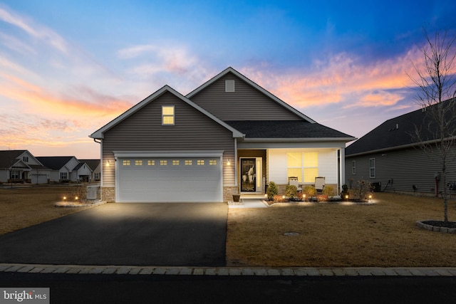 traditional home featuring a garage, concrete driveway, and stone siding