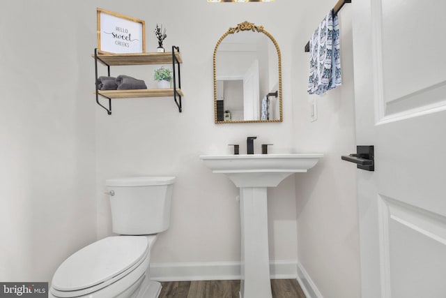 bathroom featuring toilet, baseboards, and wood finished floors