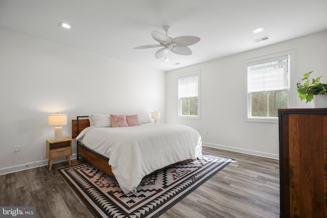 bedroom featuring a ceiling fan, baseboards, visible vents, and wood finished floors