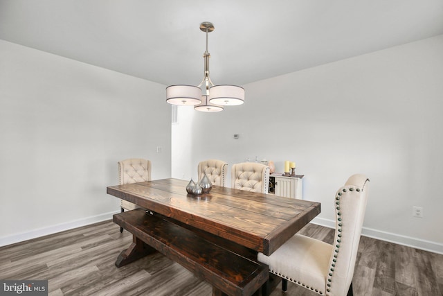 dining space with baseboards and wood finished floors