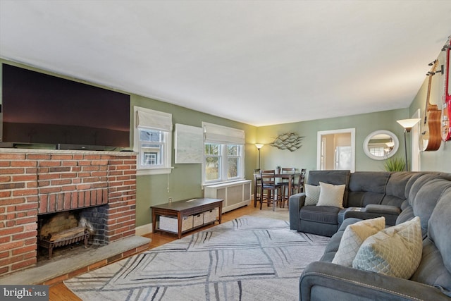 living room featuring baseboards, wood finished floors, and a fireplace