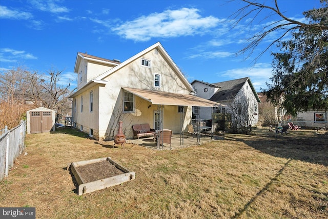 back of property featuring a storage unit, an outbuilding, a fenced backyard, a yard, and a patio area