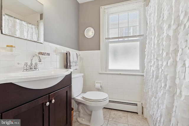 bathroom with vanity, a baseboard heating unit, tile patterned floors, toilet, and tile walls