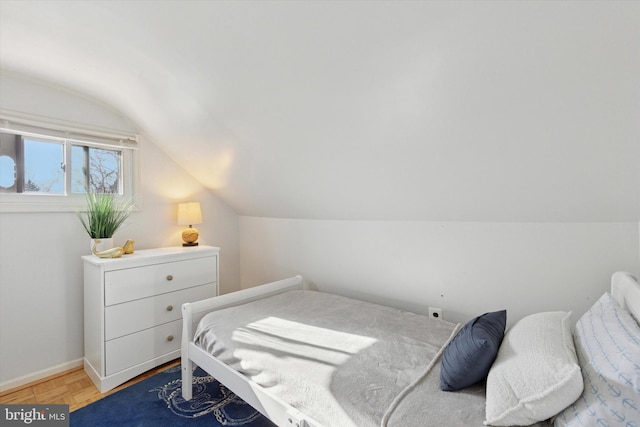 bedroom featuring vaulted ceiling and baseboards