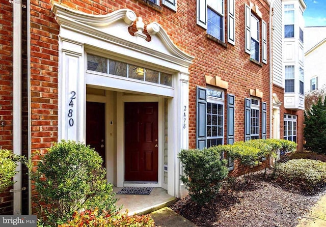 doorway to property featuring brick siding