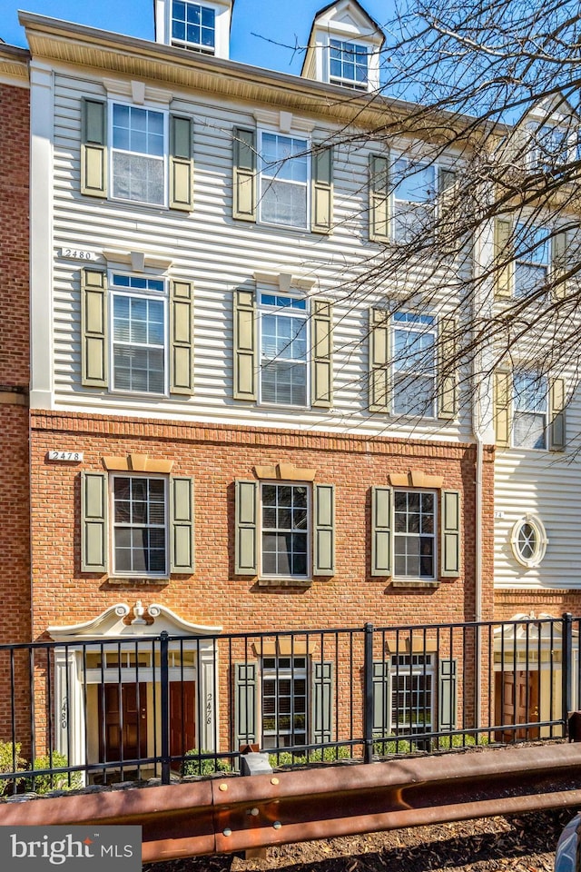 exterior space with a fenced front yard and brick siding