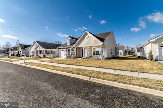 view of front facade with driveway, a garage, a residential view, and a front lawn