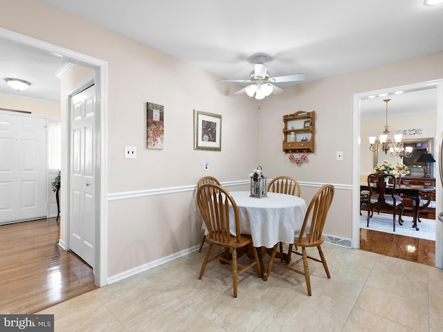 dining space featuring ornamental molding, baseboards, and light wood finished floors