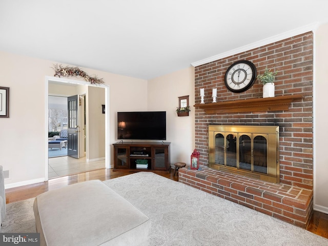 living room featuring a fireplace, wood finished floors, and baseboards