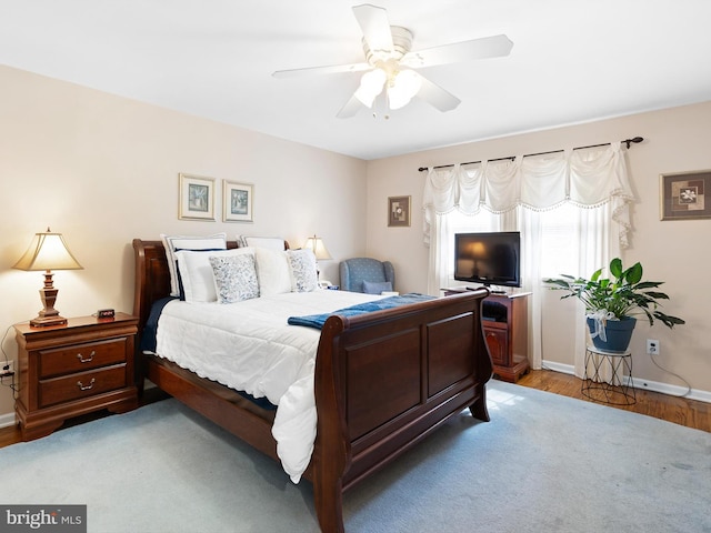 bedroom with light wood-style flooring, baseboards, and ceiling fan