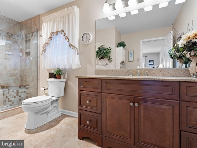 full bathroom featuring vanity, a shower stall, toilet, and baseboards