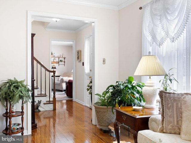 interior space with stairs, ornamental molding, and wood finished floors