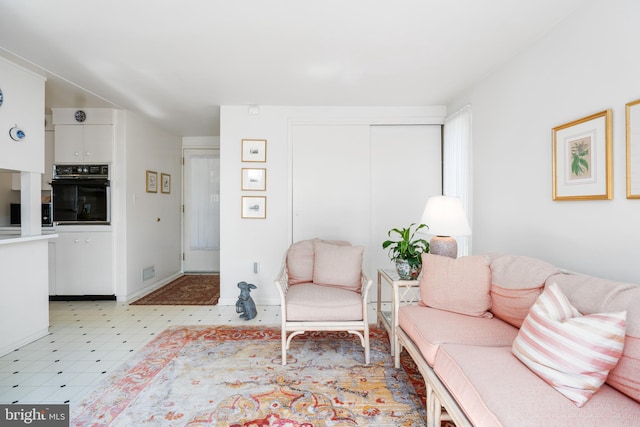 living area with light floors, visible vents, and baseboards