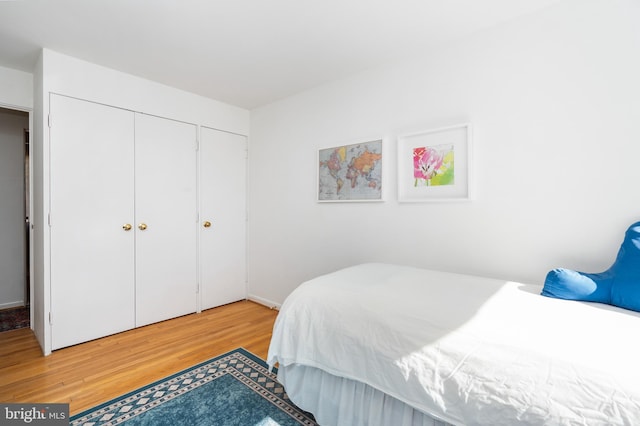 bedroom with light wood finished floors and a closet