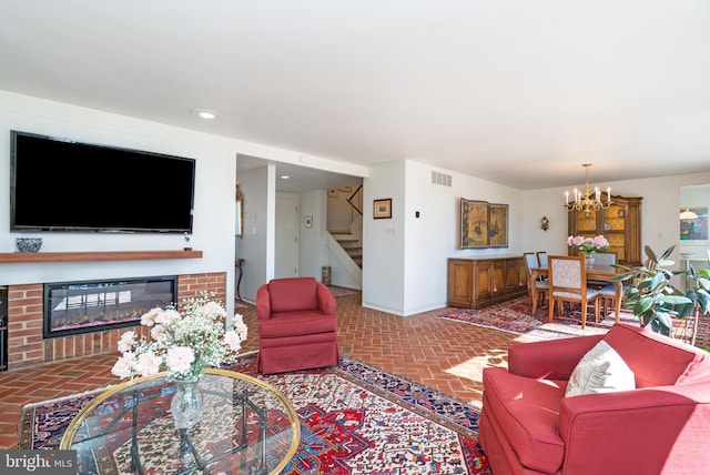 living area featuring brick floor, visible vents, baseboards, stairs, and a glass covered fireplace