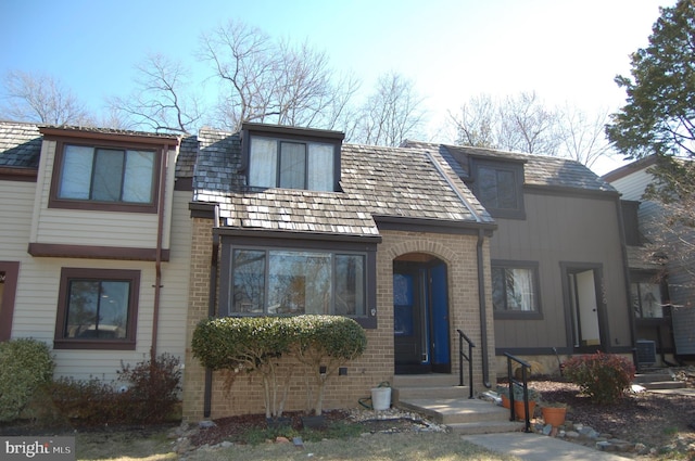 view of front of property featuring brick siding and central air condition unit