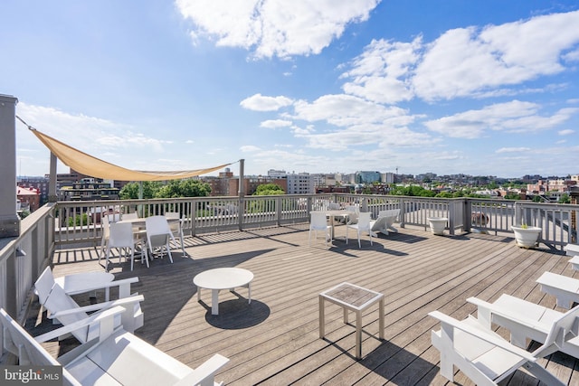 wooden terrace with a view of city and outdoor dining area