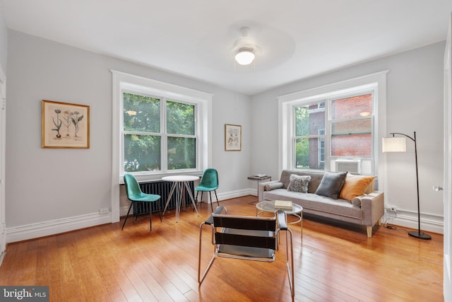 living area featuring baseboards, a healthy amount of sunlight, and light wood-style floors