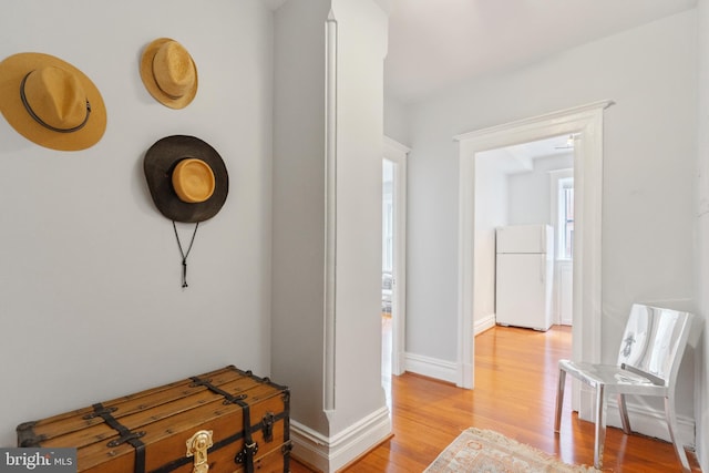 hall with light wood-type flooring and baseboards