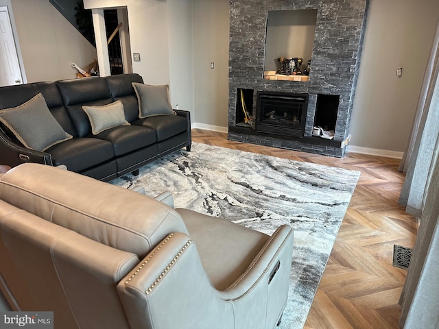 living area with visible vents, baseboards, and a stone fireplace