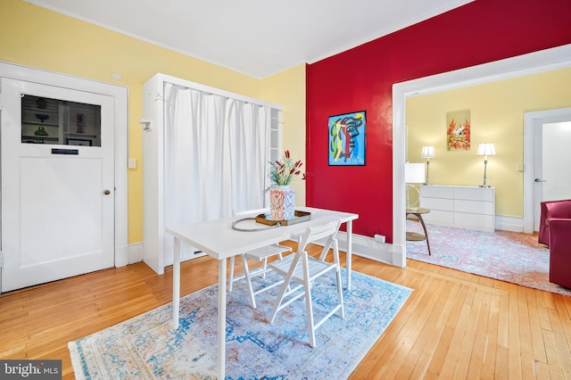 dining space with hardwood / wood-style flooring and baseboards