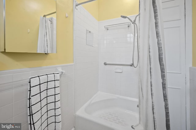 bathroom featuring a wainscoted wall and tile walls