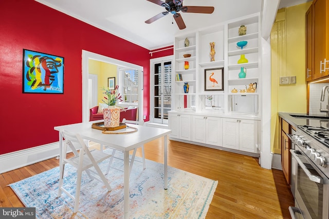 dining space featuring baseboards, ceiling fan, and light wood finished floors