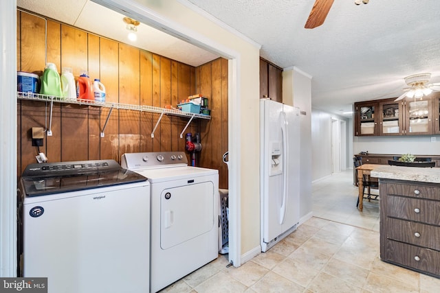 laundry room with laundry area, baseboards, a ceiling fan, a textured ceiling, and washing machine and dryer