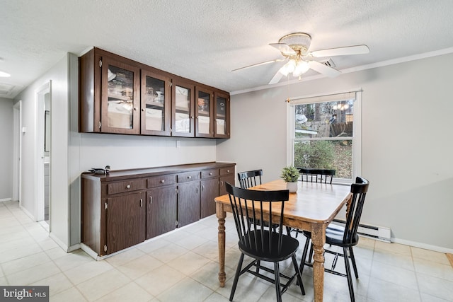 dining area featuring ceiling fan, baseboards, baseboard heating, and a textured ceiling