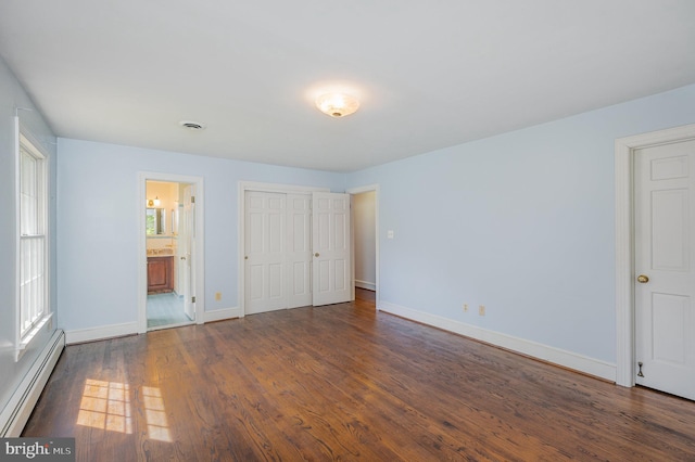 13086 Langley Rd, Bryantown, MD 20617 - unfurnished bedroom featuring wood finished floors, baseboards, ensuite bathroom, and a baseboard heating unit
