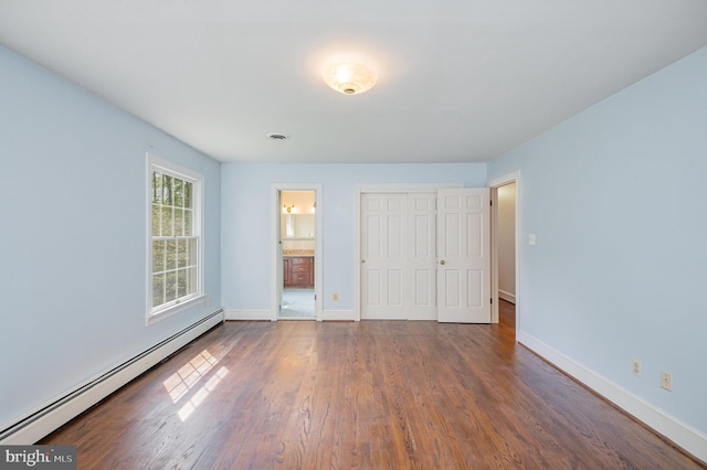 13086 Langley Rd, Bryantown, MD 20617 - unfurnished bedroom featuring a closet, baseboards, wood finished floors, and baseboard heating