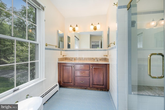13086 Langley Rd, Bryantown, MD 20617 - full bathroom with a sink, baseboard heating, tile walls, a wealth of natural light, and a stall shower