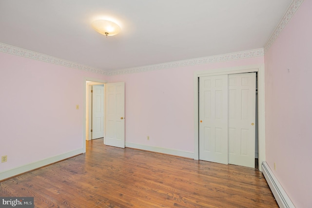 13086 Langley Rd, Bryantown, MD 20617 - unfurnished bedroom featuring baseboards, a baseboard heating unit, wood finished floors, and a closet