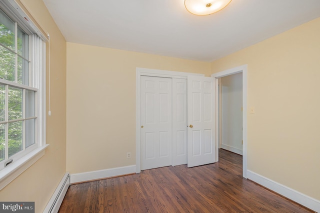 13086 Langley Rd, Bryantown, MD 20617 - unfurnished bedroom featuring dark wood finished floors, baseboard heating, and multiple windows
