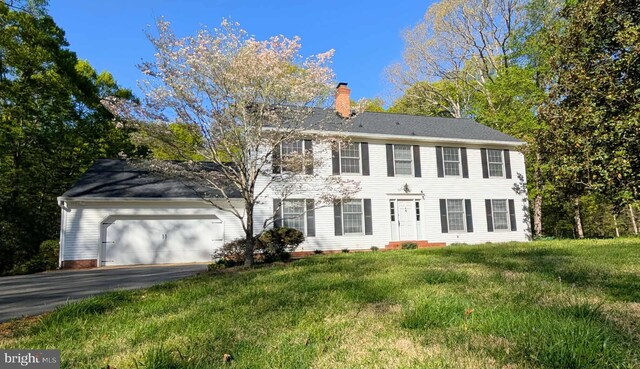 13086 Langley Rd, Bryantown, MD 20617 - colonial-style house featuring driveway, a chimney, a front lawn, and a garage